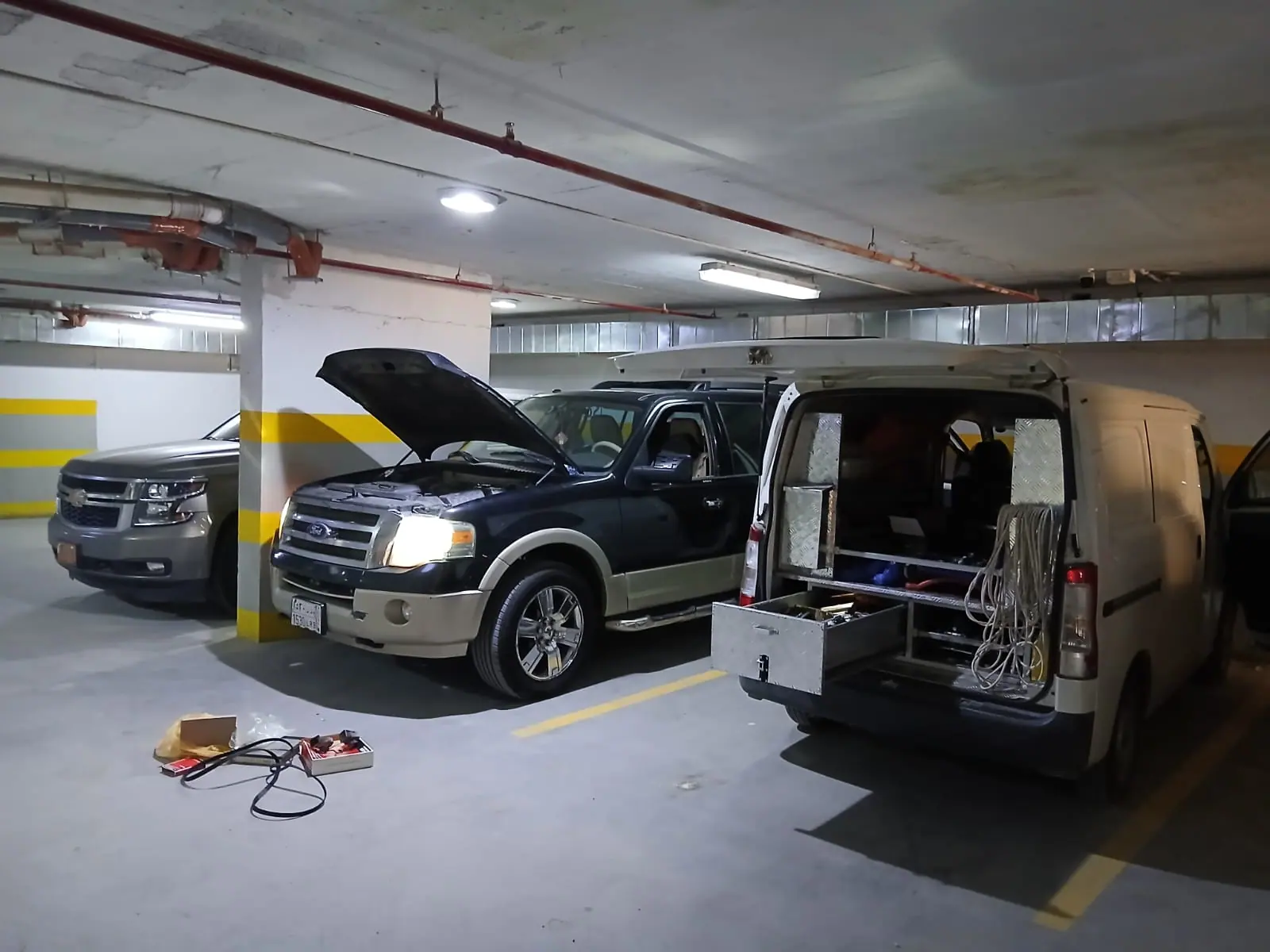Saaed Service van and a Ford Expedition with the bonnet up in a Riyadh underground car park